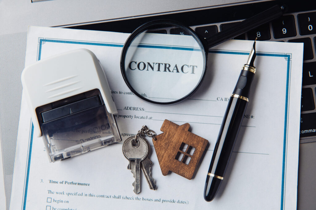 First Time Home Buyer Colorado, House keys, magnifying glass and contract. Concept of rent, search or mortgage house